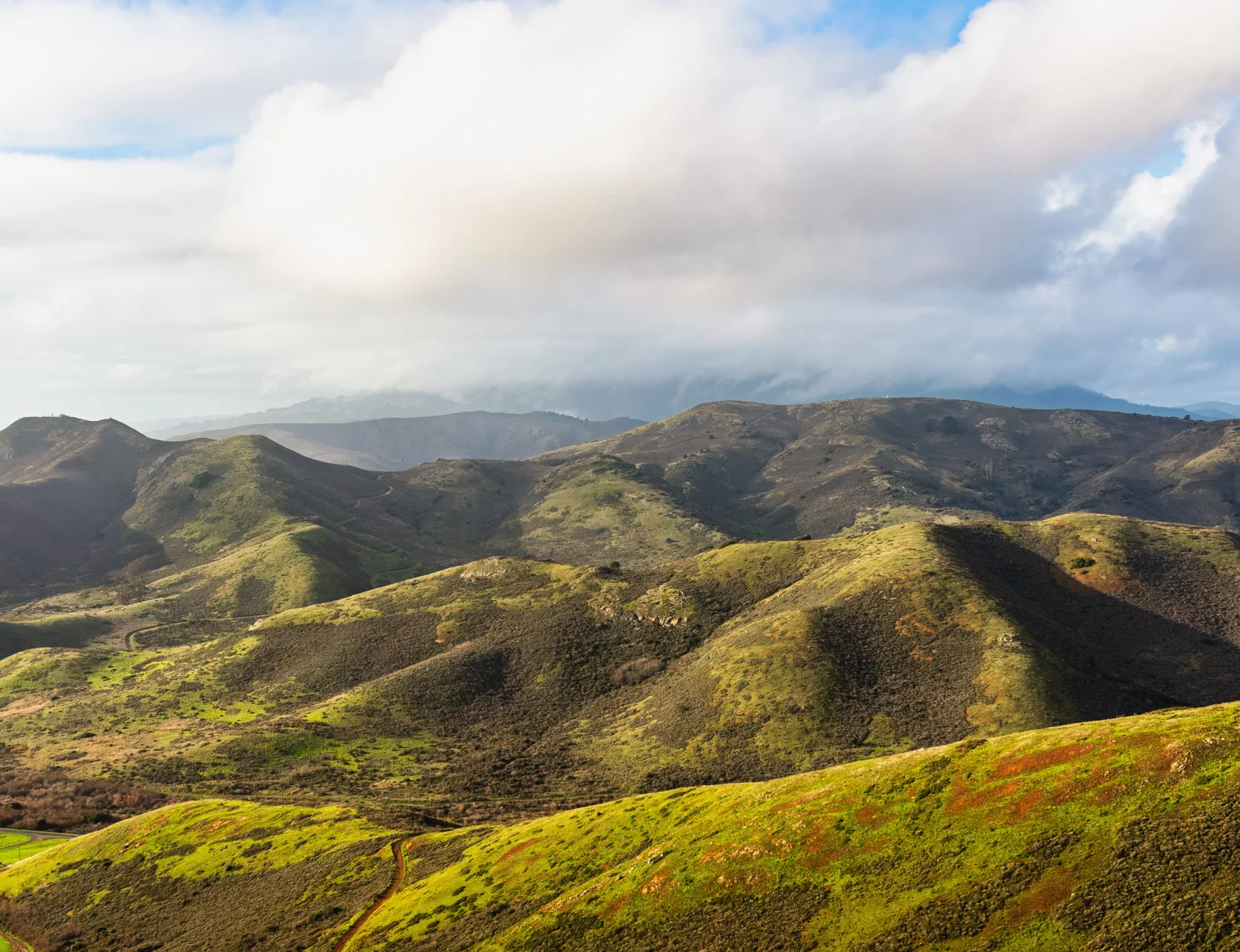 Green Marin hills beneath a clouded sky